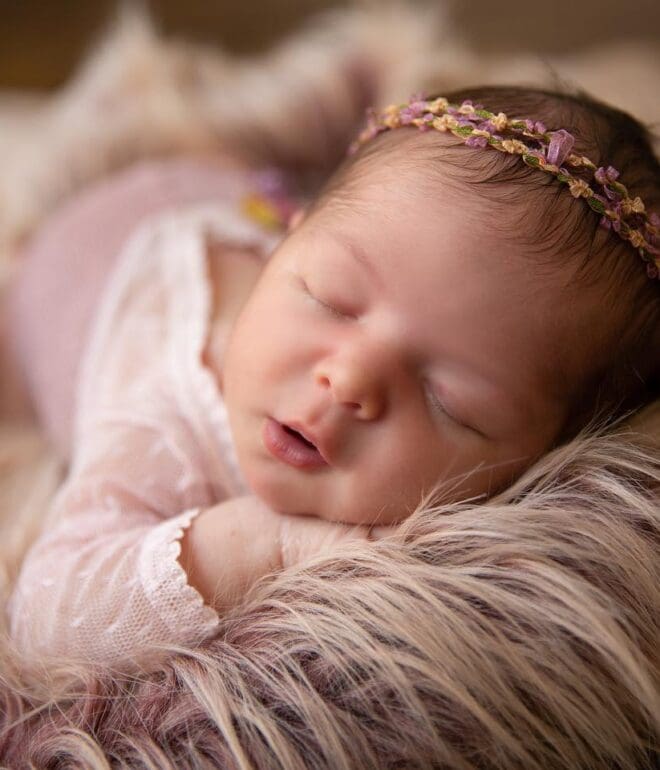 A baby sleeping on a furry blanket